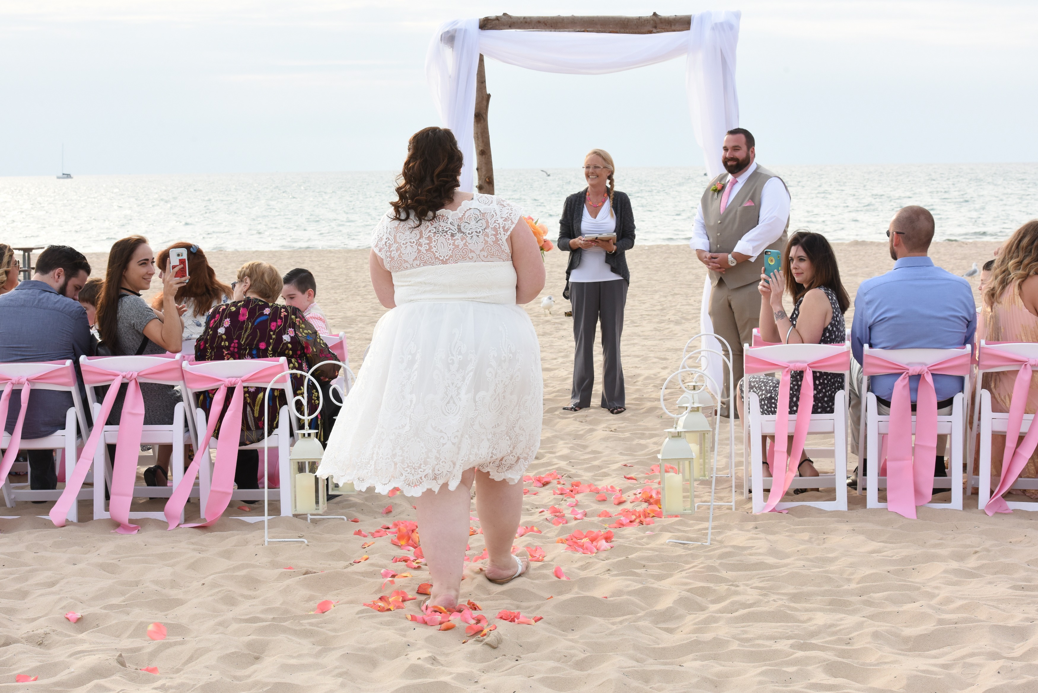 bride walks down an asile of sand