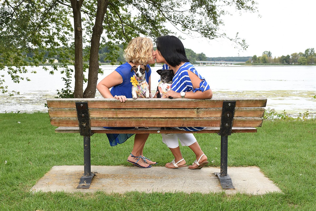 LGBT couple kissing on a park bench at wade's bayou memorial park