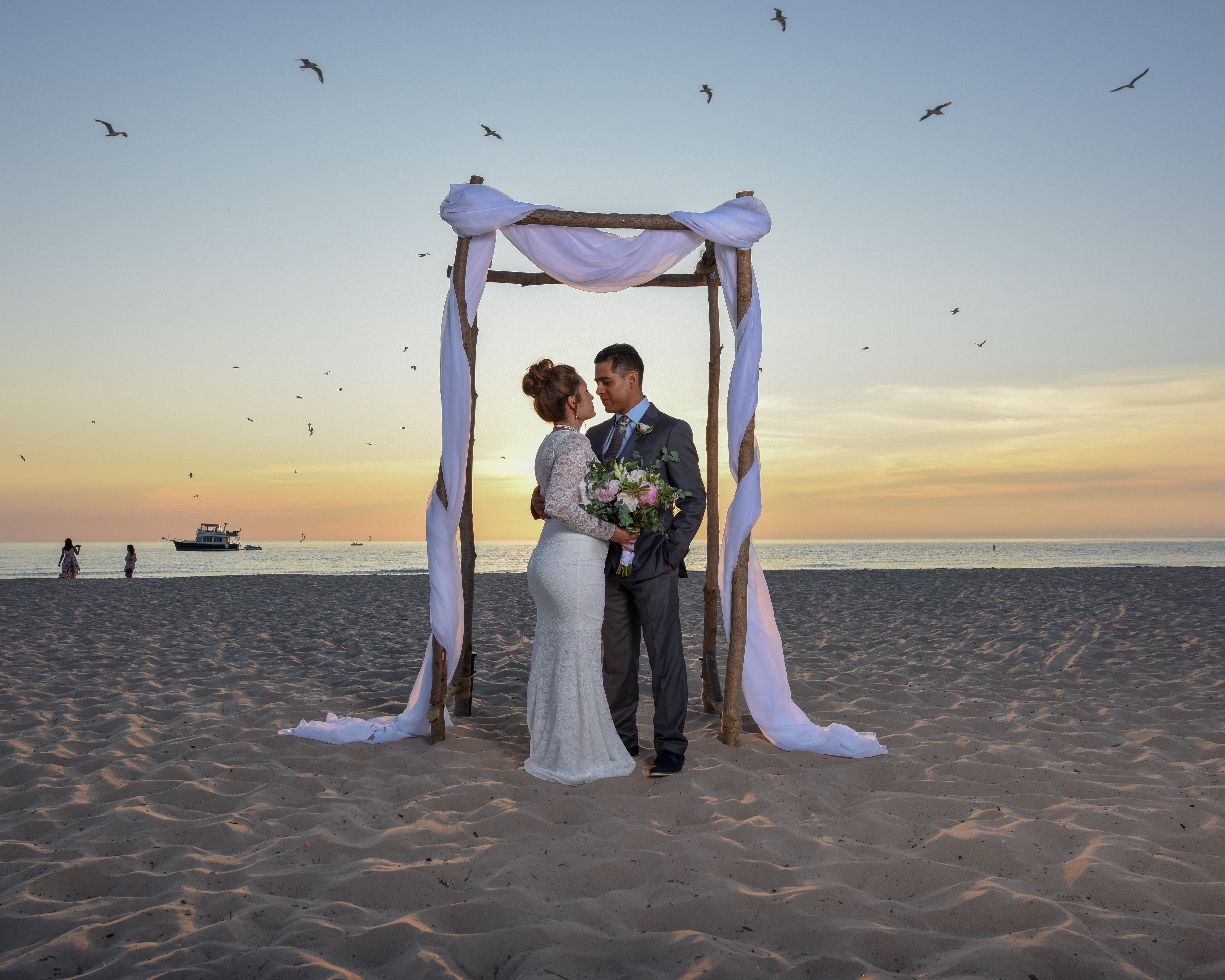 couple under beach wedding abor